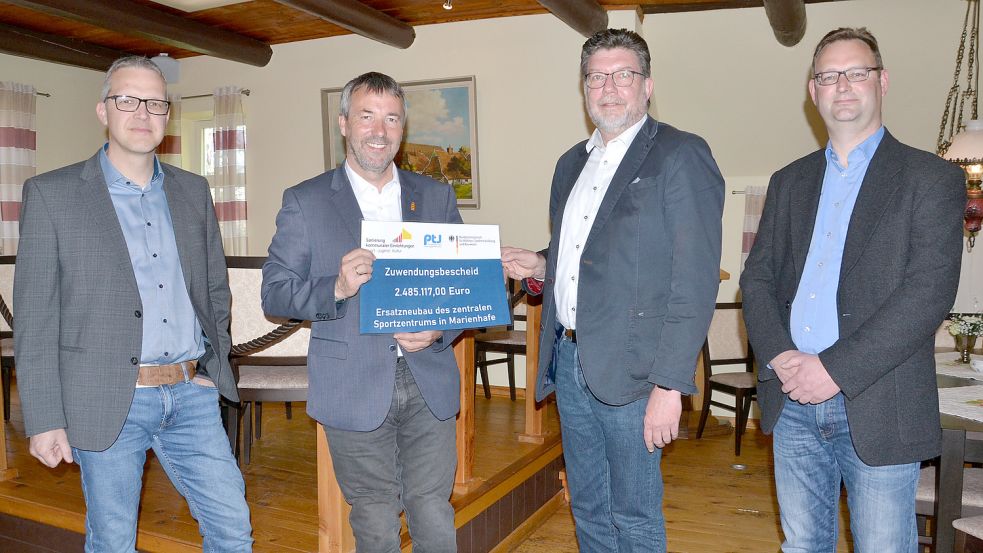 Johann Saathoff (2. von links) hat den Bescheid an Bauamtsleiter Jochen Behrends (von links), Samtgemeindebürgermeister Gerhard Ihmels (SPD) und Bauamtsmitarbeiter Markus Schwarz überreicht. Foto: Wenzel