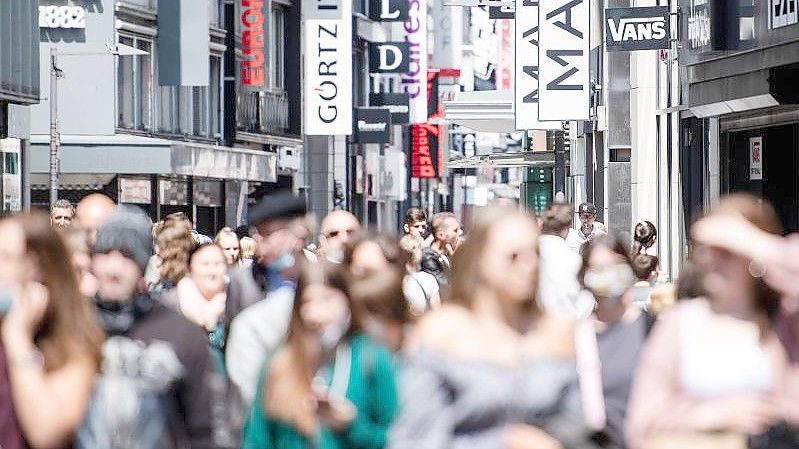 Menschen gehen über die Hohe Straße in Köln. Foto: Marius Becker/dpa
