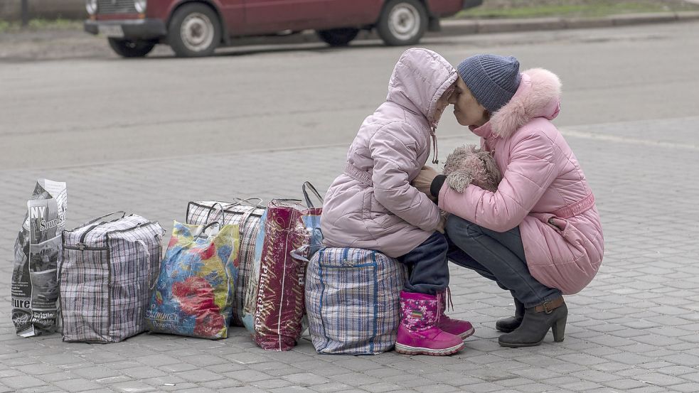 Eine Mutter umarmt ihre Tochter, während sie auf einen Bus warten, um aus der Stadt Slowjansk im Bezirk Donezk nach Riwne im Nordwesten der Ukraine zu fliehen. Foto: DPA