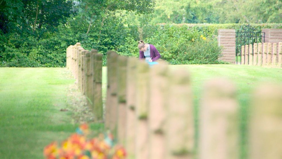 Ein Bild mit Symbolkraft: Eine Jugendliche notiert ihre Gedanken beim Anblick von Kriegsgräbern von jungen Männern auf dem deutschen Soldatenfriedhof in der französischen Gemeinde St. Désir. Foto: Privat/Archiv