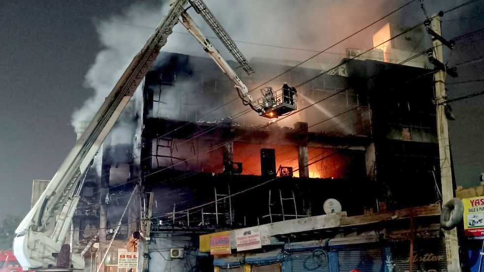Feuerwehrleute versuchen, den Brand zu löschen. Foto: Dinesh Joshi/AP/dpa