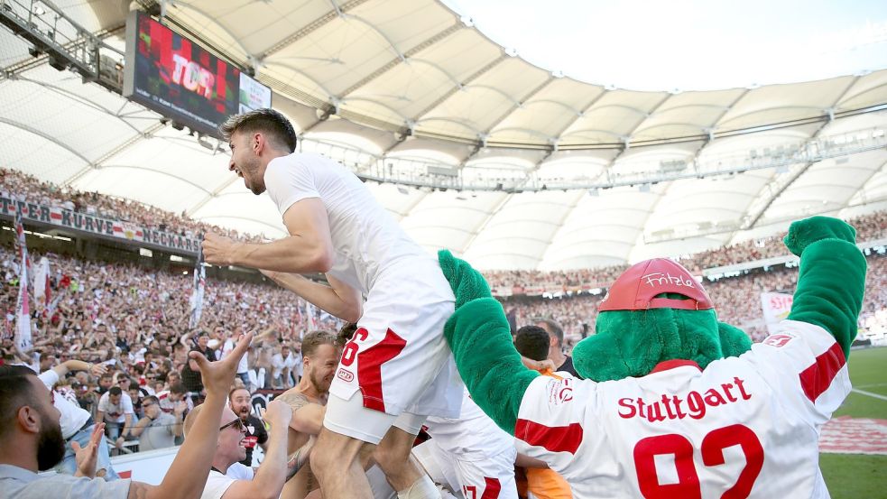 Der Stuttgarter Atakan Karazor (l) feiert mit den Fans das späte Tor zum 2:1 durch Endo. Foto: Tom Weller/dpa