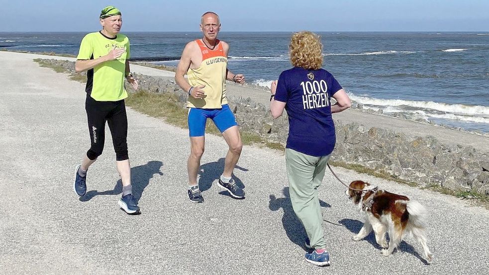 Laufen hier die Männer (links Helge Rademacher, daneben Klaus Arping) in die Frau mit ihrem Hund rein? Nein. Auch wenn es nicht so aussieht, sie laufen alle in die gleiche Richtung. Denn die Männer „rennen“ rückwärts.