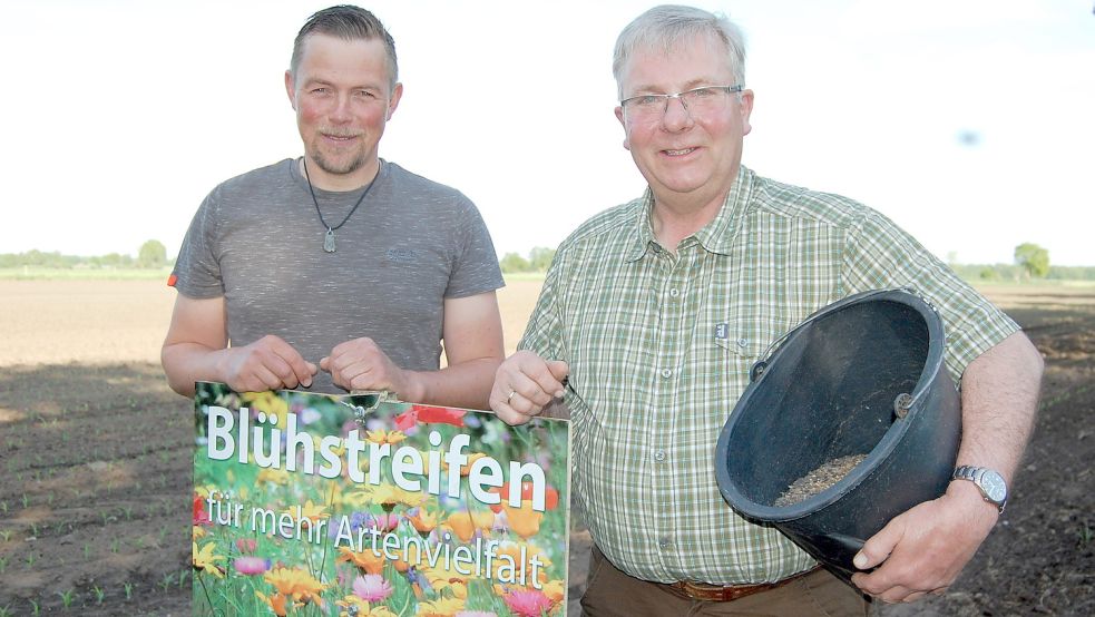 Armin Duin (links) und Heiko Duin von der Jagdgemeinschaft Hasselt stehen vor einem Maisacker. An dessen Rändern wurden Wildblumen ausgesät. Zudem wachsen dort Pflanzen heran, die Rehen, Hasen, Fasanen und Rebhühnern besonders gut schmecken. Foto: Schneider-Berents