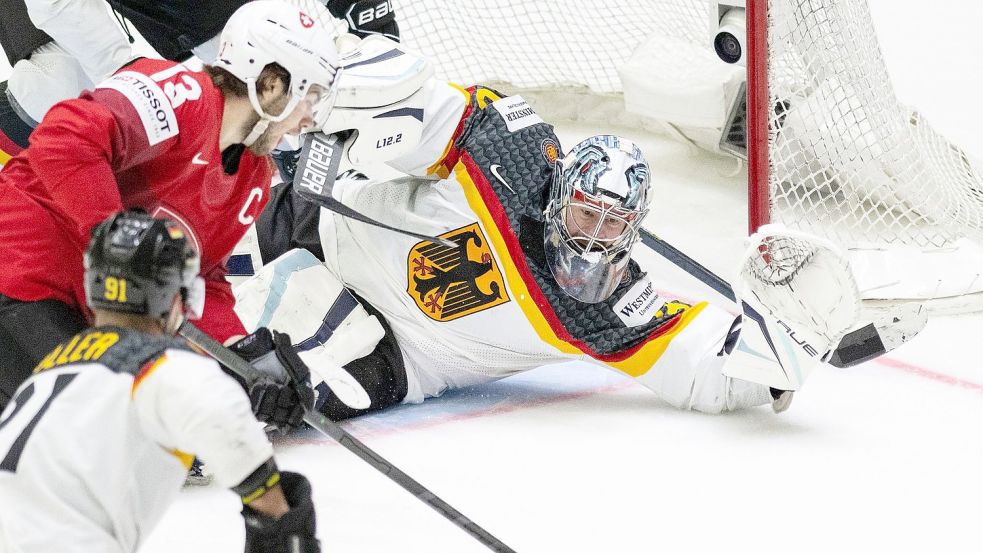 Der Schweizer Nico Hischier (l) und Deutschlands Torwart Philipp Grubauer (r) in Aktion. Foto: Peter Schneider/KEYSTONE/dpa