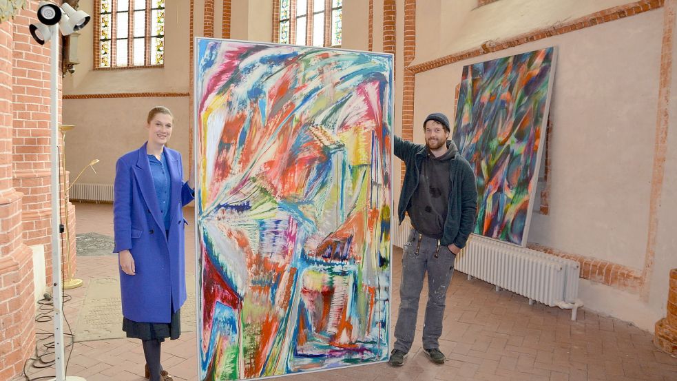 Freuen sich auf die Biennale: Organisatorin Ina Grätz und Künstler Jan Pleitner beim Arrangieren der Bilder in der Norder Ludgerikirche. Dort wird die Ausstellung am Sonnabend ab 15 Uhr eröffnet. Foto: Hillebrand