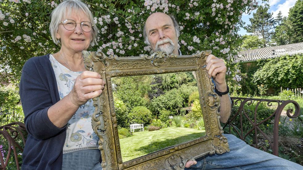 Unter einem Dach aus den Blüten der Rose „Paul’s Himalayan Musk“ sitzen Magdalene und Hermann Kempen. Der Spiegel zeigt, wie es im hinteren Teil aussieht. Fotos: Ortgies