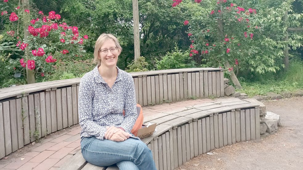 Birgit Weusmann sitzt auf einer Sitzecke im Botanischen Garten. Ähnlich wie diese sind einige Freiluftklassenzimmer gestaltet. Foto: Vogt