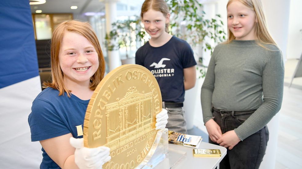 Die Fünftklässlerinnen der Oberschule Remels beim Versuch, Europas größte Goldmünze anzuheben. Fotos: Stromann