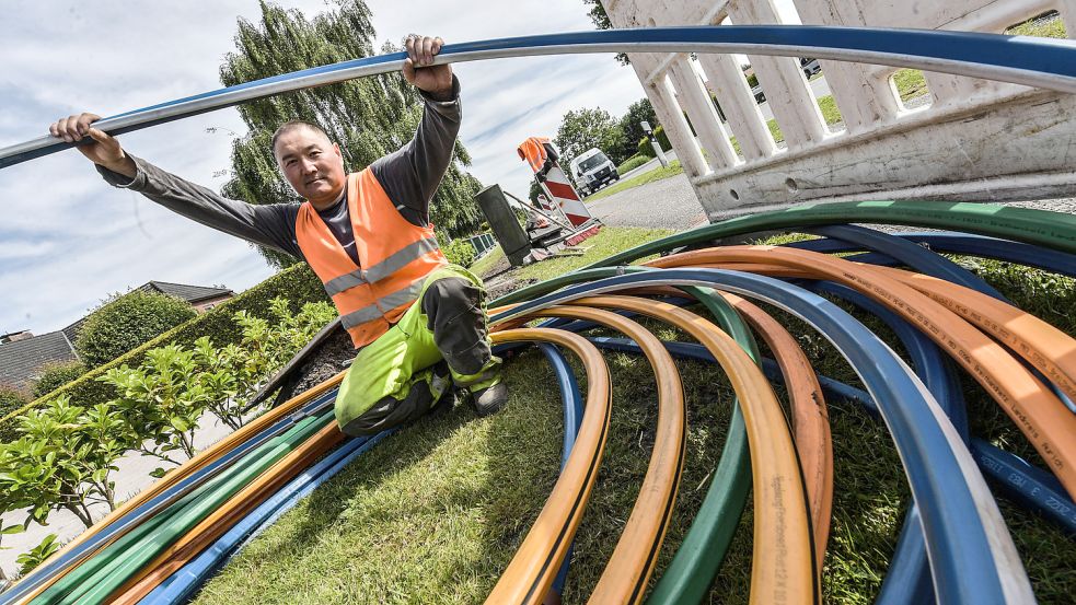 Ein Arbeiter in Südbrookmerland greift sich ein Leerrohr, in das später Glasfaserkabel eingeblasen werden. Foto: Ortgies