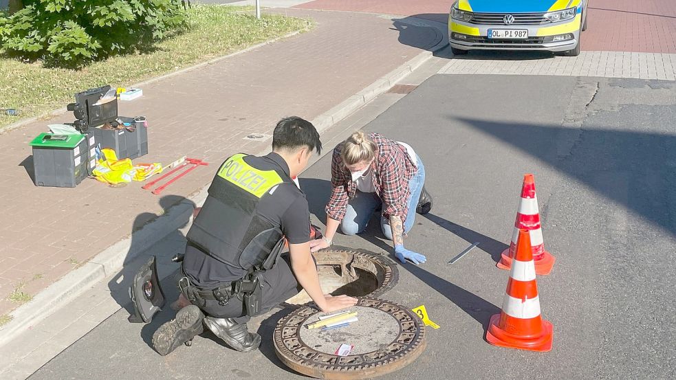 Polizisten inspizieren einen Gully - der Junge wurde hier nach mehr als einer Woche wiedergefunden. Foto: Andre van Elten/dpa