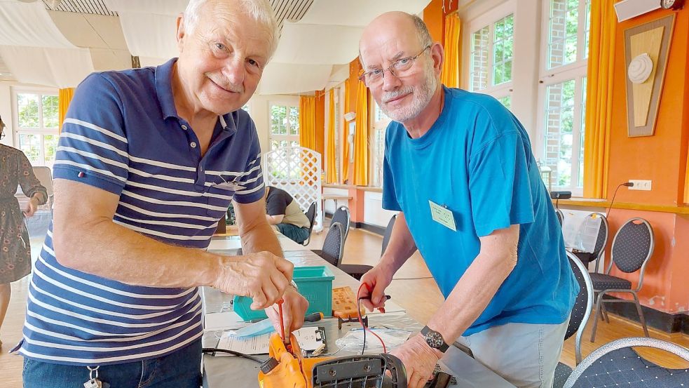 Diese Kettensäge wäre wohl auf dem Müll gelandet, wenn Ulrich Diekmann (links) und Heinz Hugen mit geschickten Griffen kein neues Kabel verlegt hätten. Fotos: Hanssen