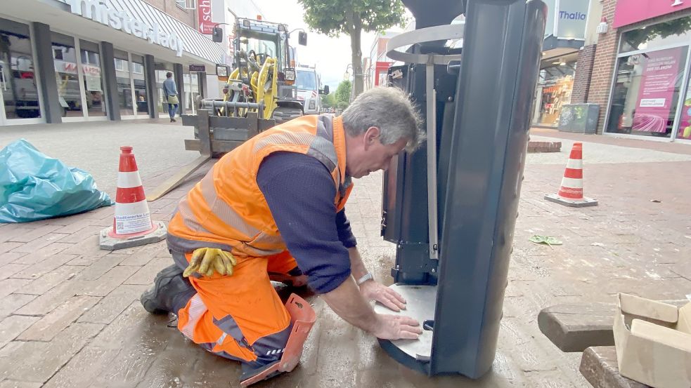 Ein Mitarbeiter der Stadtwerke installiert einen neuen Abfalleimer in der Mühlenstraße. Foto: Stadtwerke