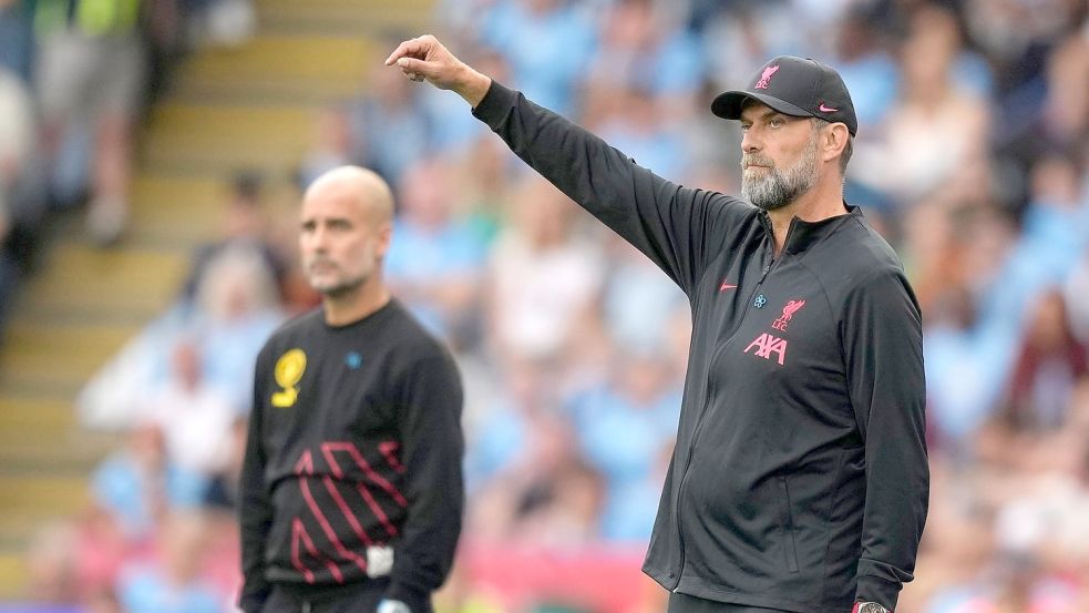 City-Trainer Pep Guardiola (l) und Liverpools Coach Jürgen Klopp stehen an der Seitenlinie. Foto: Frank Augstein/AP/dpa