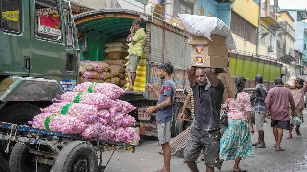 Ein Mann in Colombo mit einer Ladung importierter Lebensmittel auf einem Markt. Foto: Eranga Jayawardena/AP/dpa