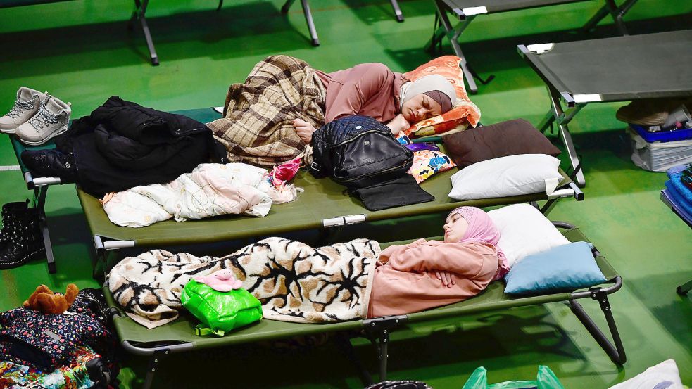 Frauen, die aus der Ukraine geflüchtet sind, liegen auf Feldbetten in einer zur Notunterkunft umfunktionierten Turnhalle. Ein solches Szenario will der Landkreis Aurich verhindern. Foto: Monus/dpa
