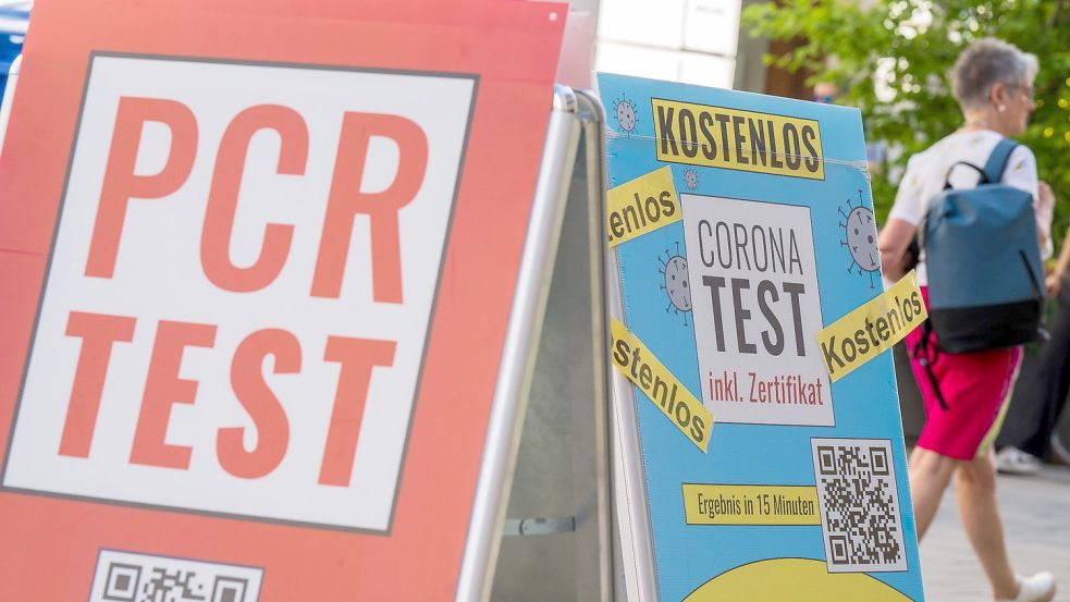 PCR-Tests werden am Eingang einer Apotheke in der Münchner Innenstadt beworben. Foto: Peter Kneffel/dpa