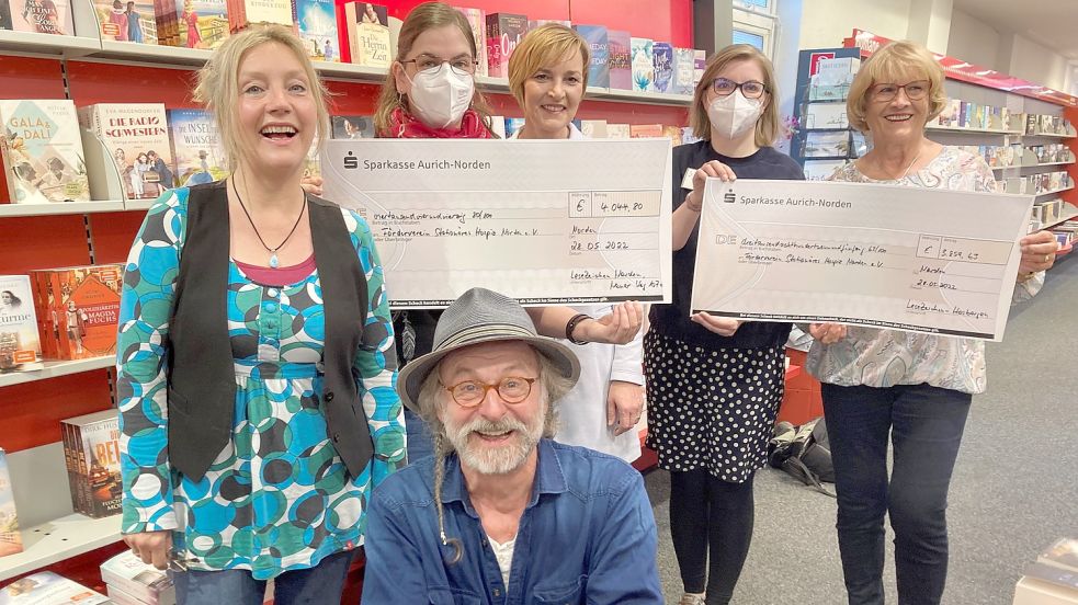Klaus-Peter Wolf (Bildmitte) hat am Wochenende bei einer Autogrammstunde in der Buchhandlung „Lesezeichen“ in Norden wieder Spenden an den Förderverein „Hospiz am Meer“ übergeben. Foto: Rebecca Kresse