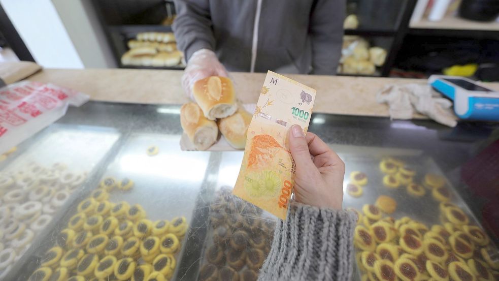 Eine Frau zahlt mit einem 1000-Pesos-Schein in einer Bäckerei. Foto: Claudio Santisteban/dpa