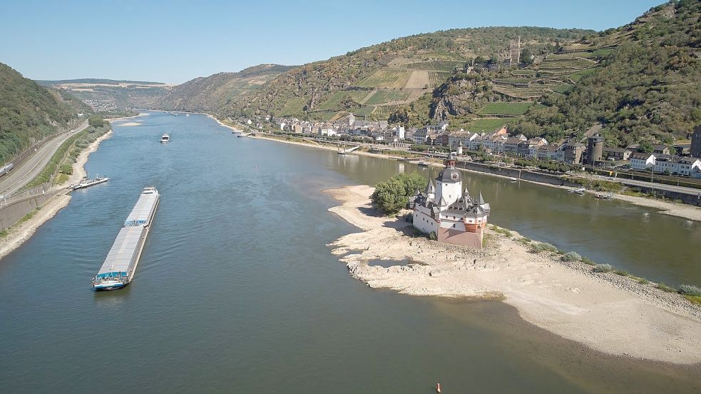 Ein Schubverband passiert die Zollburg Pfalzgrafenstein am Mittelrhein bei Kaub. In Kaub wird einer der wichtigsten Bezugspegel für die Rheinschifffahrt am Mittelrhein gemessen. Foto: Thomas Frey/dpa