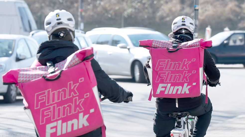 Zwei Fahrradkuriere mit Rucksäcken des Lebensmittel-Lieferdienstes Flink. Foto: Sebastian Kahnert/dpa-Zentralbild/dpa