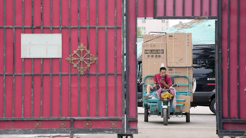 Ein Zusteller transportiert Haushaltsgeräte von einem Auslieferungszentrum. Foto: Ng Han Guan/AP/dpa