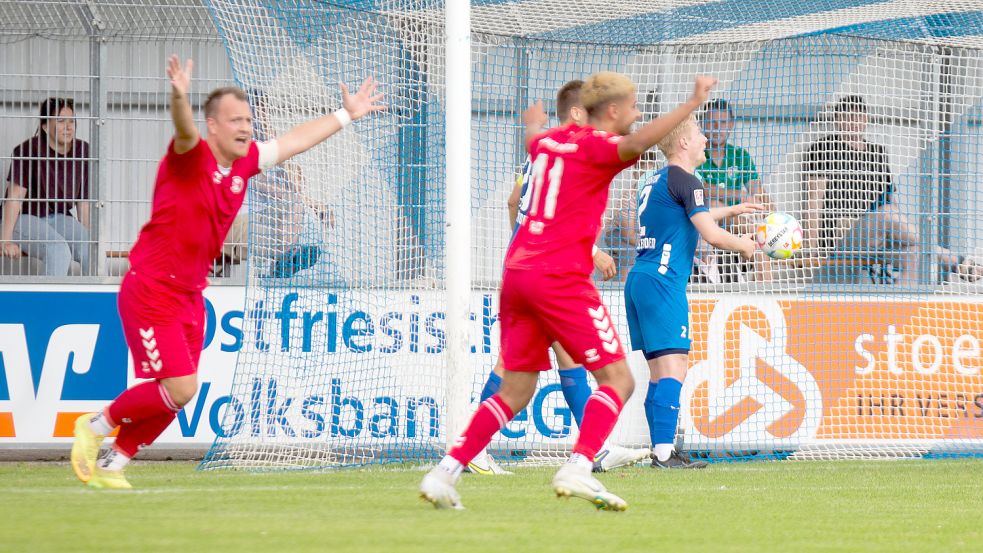 Gäste-Kapitän Jan Lüneburg (links) und Doppel-Torschütze Elias Saad jubeln nach dem Kopfball-Treffer von Yannik Nuxoll (nicht im Bild). Emdens Nick Köster (hinten) konnte den wuchtigen Ball aus sechs Metern nicht mehr rausköpfen und nur noch dem Ball nach dem 0:2 aus dem Netz holen. Fotos: Doden/Emden