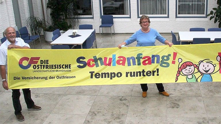 Hans-Friedel Walther, Vorsitzender der Verkehrswacht Aurich, und Signe Foetzki, Pressesprecherin der Brandkasse, präsentieren eines der neuen Banner. Foto: Brandkasse