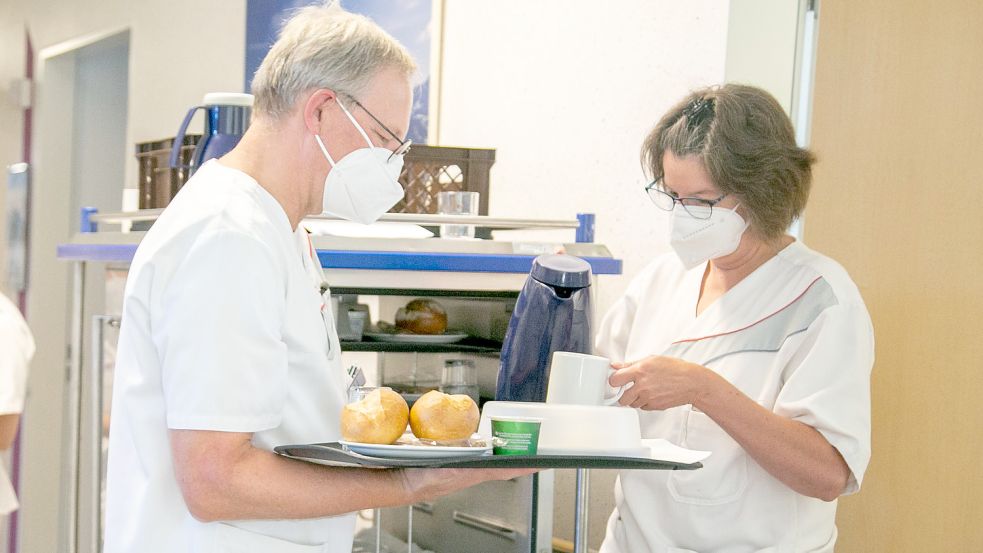 Dr. Thomas Günnewig (links) hilft Schwester Anke Kunze beim Verteilen der Frühstücks-Tabletts. Foto: Elisabeth Krankenhaus Recklinghausen/Kristina Schröder