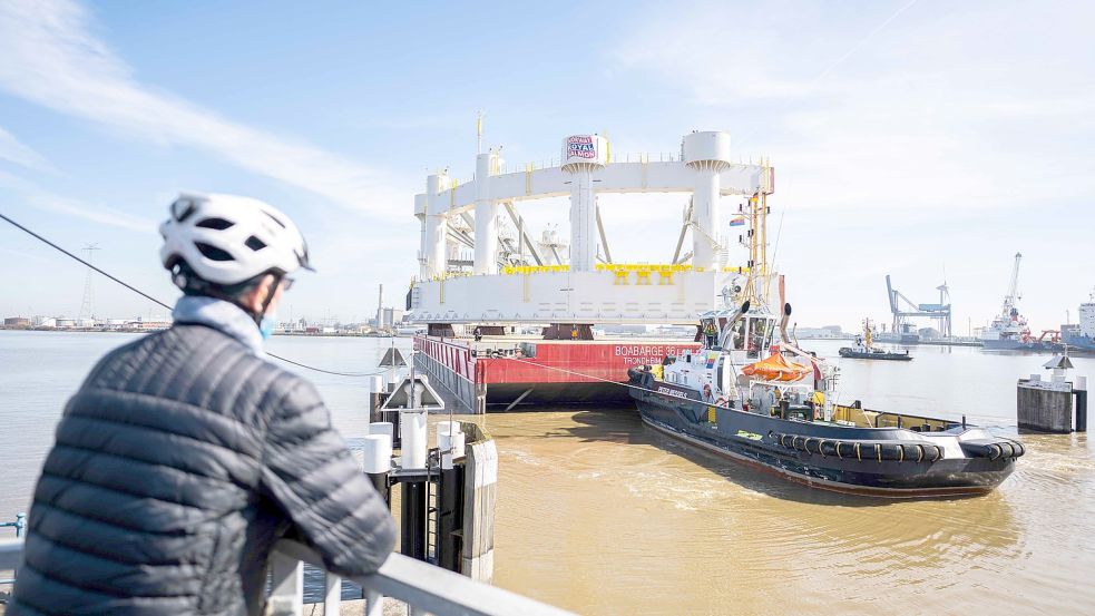 Ein von der Emder Werft Fosen Yard gebautes Teil für eine Hochsee-Lachsfarm wird auf einem Ponton von zwei Schleppern aus dem Emden Hafen bewegt. Es war die letzte größere Bauteile-Lieferung für Fosen Emden. Foto: Archib/Mohssen Assanimoghaddam/DPA