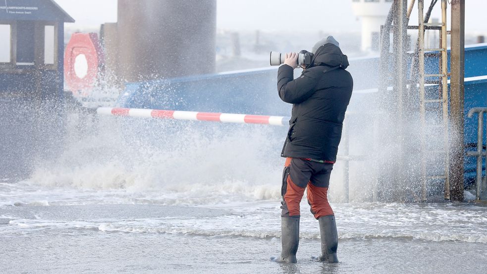 Das Bild entstand Ende Januar 2022 in Dagebüll: ein Fotograf bei Sturm am Fähranleger. Foto: Marks/dpa