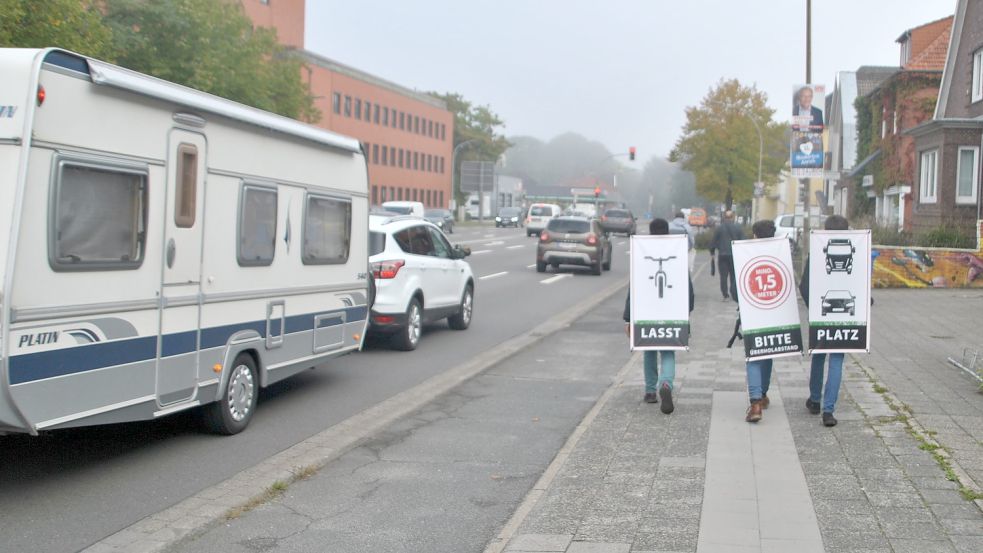 Mit Botschaft auf dem Rücken gehen Metkel, Abdul und Mohammed die Esenser Straße entlang. Foto: Schönig