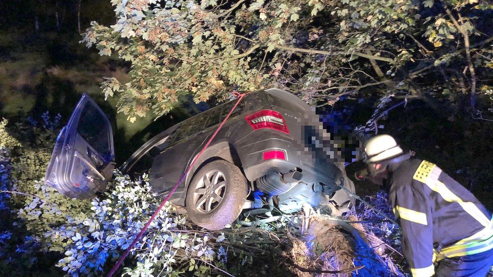 Auf einem großen Busch, den der Wagen zuvor entwurzelt und überrollt hatte, kam das Auto zum Stehen. Ein Feuerwehrmann kontrollierte, ob Betriebsstoffe auslaufen. Foto: Ammermann