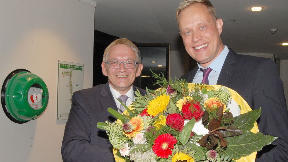 Landrat Olaf Meinen (links) gratulierte Wahlsieger Wiard Siebels (SPD) mit einem Blumenstrauß. Fotos: Luppen