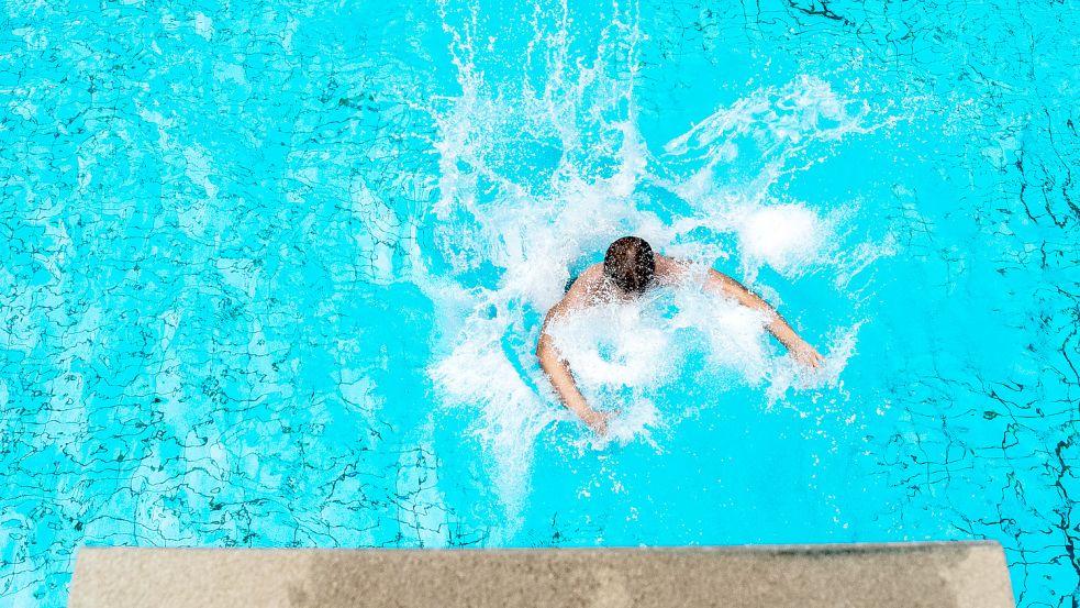 Der Sprung ins kühlere Wasser: Angesichts hoher Energiepreise senken die Schwimmbäder in Ostfriesland ihre Wassertemperaturen. Foto: M. Assanimoghaddam/dpa