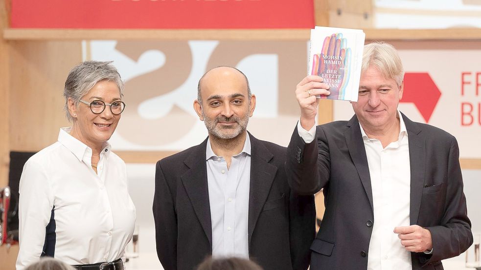 Börsenverein-Vorsteherin Karin Schmidt-Friderichs, der Autor Mohsin Hamid und Buchmessen-Direktor Jürgen Boos in Frankfurt. Foto: Sebastian Christoph Gollnow/dpa