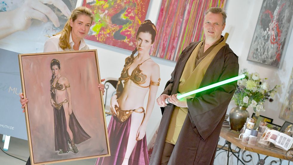 Katja Freimuth hält ihr Gemälde von Prinzessin Leia aus Star Wars. Ganz rechts steht Matthias Hinrichs, der sich als Obi-Wan Kenobi verkleidet hat. Fotos: Ortgies