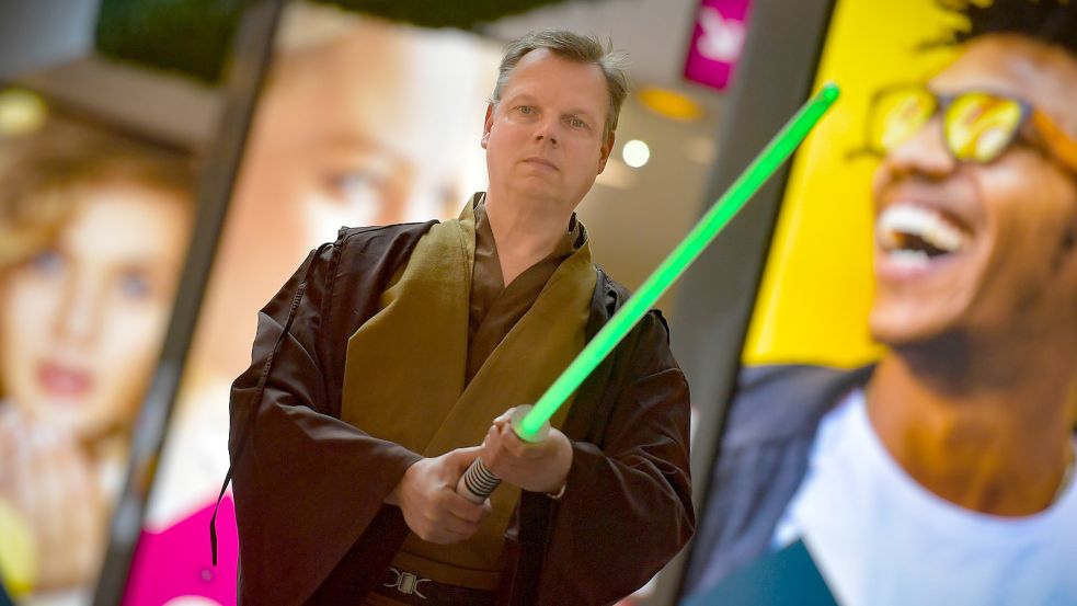 Matthias Hinrichs, Gründungsmitglied des Star-Wars-Fanclubs IZWE, ist als Obi-Wan Kenobi verkleidet. Mit dem Lichtschwert in der Hand wartet er auf Darth Vader.