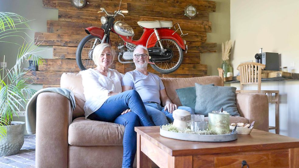 Ina und Frank Meyburg in ihrem Wohnzimmer. Das Moped des Großvaters an der Wand ist nur einer der Hingucker. Foto: Hock