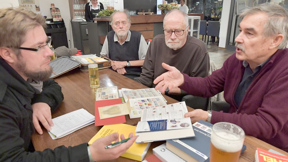 Reporter Claus Hock (links) hat sein altes Briefmarkenalbum wiedergefunden. Er ließ sich von Klaus Wiener (gegenüber, von links), Wilhelöm Penzler und Günter von Nordheim erklären, was es mit dem Hobby auf sich hat. Foto: Ortgies