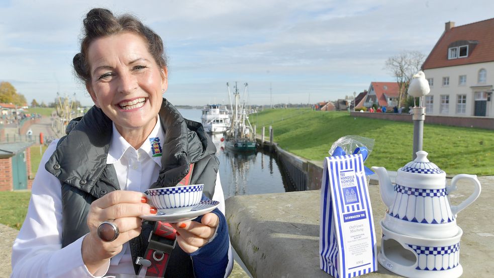 Gästeführerin Doris Voss hat mit dieser Zeitung die kulinarische Führung durch Greetsiel einmal durchgespielt. Tee gibt es normalerweise aber im Handelskontor, nicht am Hafen. Foto: Ortgies