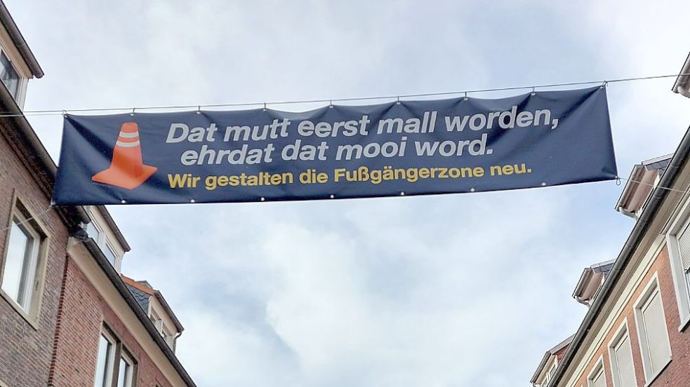 Es muss erst schlimm werden, bevor es schön wird, steht auf Plattdeutsch auf dem Banner über der Fußgängerzone.