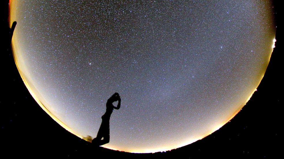 Aufnahme am Hellort von Spiekeroog: Die Skulptur „De Utkieker“ zeichnet sich vor dem Sternenhimmel ab. Foto: Hänel/dpa