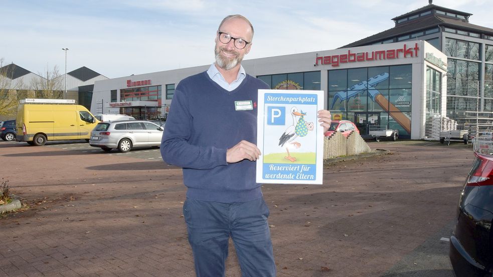 Marktleiter Stefan Lehrke zeigt seinen Entwurf für das künftige „Storchenparkplatz“-Schild für werdende Eltern, dass nach zwei Not-Geburten auf dem Parkplatz des Hagebaumarkts aufgestellt werden soll. Foto: Gernot Kühl