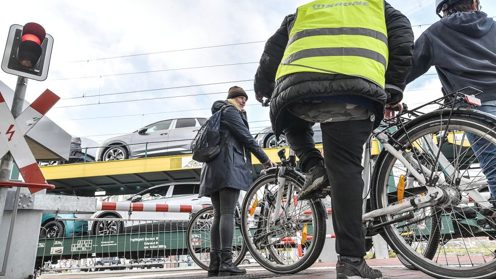 Auch viele Radfahrer stehen am Bahnübergang und warten darauf, dass sich die Schranken wieder öffnen. Foto: Ortgies