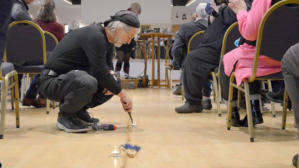 Der Norder Krimiautor Klaus-Peter Wolf ist der Schirmherr des Hospizes und durfte eine der Kerzen auf dem symbolischen Pfad entzünden, mit dem Christina Bitiq und Miriam Glave zurückblickten. Foto: Hillebrand