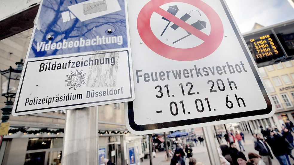 Hinweisschilder auf Videoüberwachung und Böllerverbot hängen am Zugang zur Altstadt in Düsseldorf. Foto: Martin Gerten/dpa