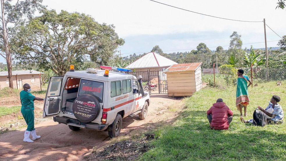 Ein medizinischer Mitarbeiter der Uganda Red Cross Society fordert Menschen mit Verdacht auf eine Ebola-Erkrankung dazu auf, in einen Krankenwagen einzusteigen. Foto: Hajarah Nalwadda/AP/dpa