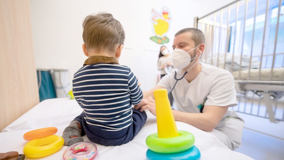 Ein Arzt untersucht in einer Kinderklinik ein Kind. Foto: Sebastian Gollnow/dpa