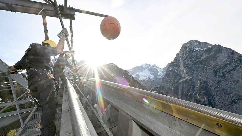 Arbeiter der Bayerischen Zugspitzbahn in Garmisch-Partenkirchen bei der alljährlichen Seilbahnrevision. Foto: Angelika Warmuth/dpa